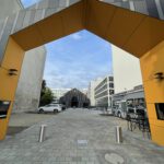 Blick von der Straße durch das Portal auf das neue Gebäude; davor der fertig gepflasterte Hof.