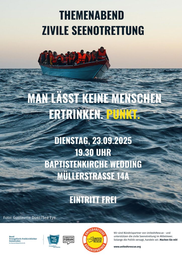Menschen mit Rettungswesten auf einem kleinen Boot im Meer.