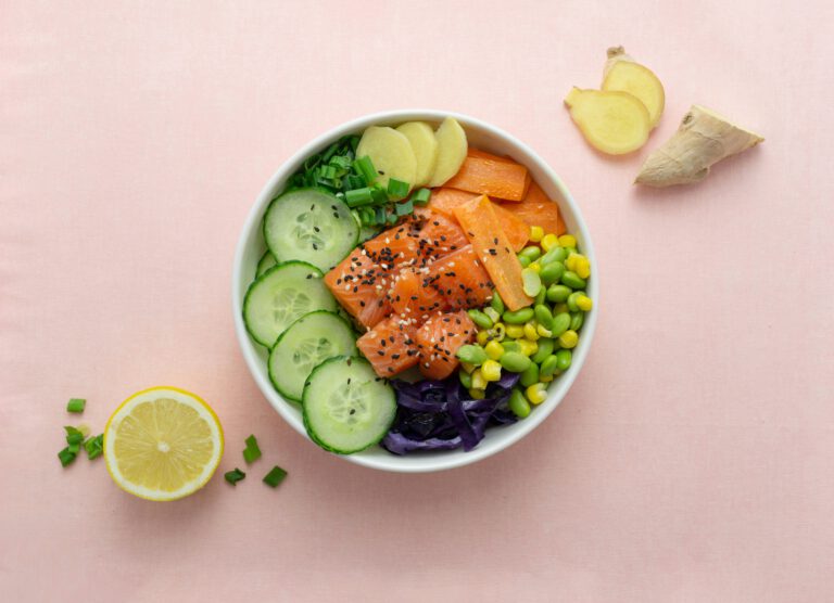 Eine Bowl von oben fotografiert. Zu sehen ist Lachs, Zitrone, Gurke.